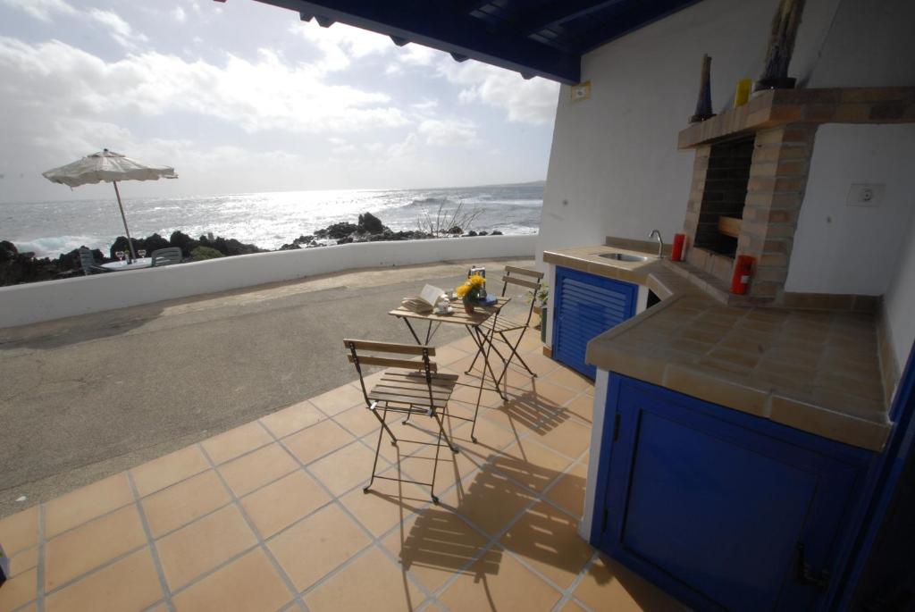 eine Küche mit Tisch und Blick auf das Meer in der Unterkunft Punta mujeres casitas del mar in Arrieta