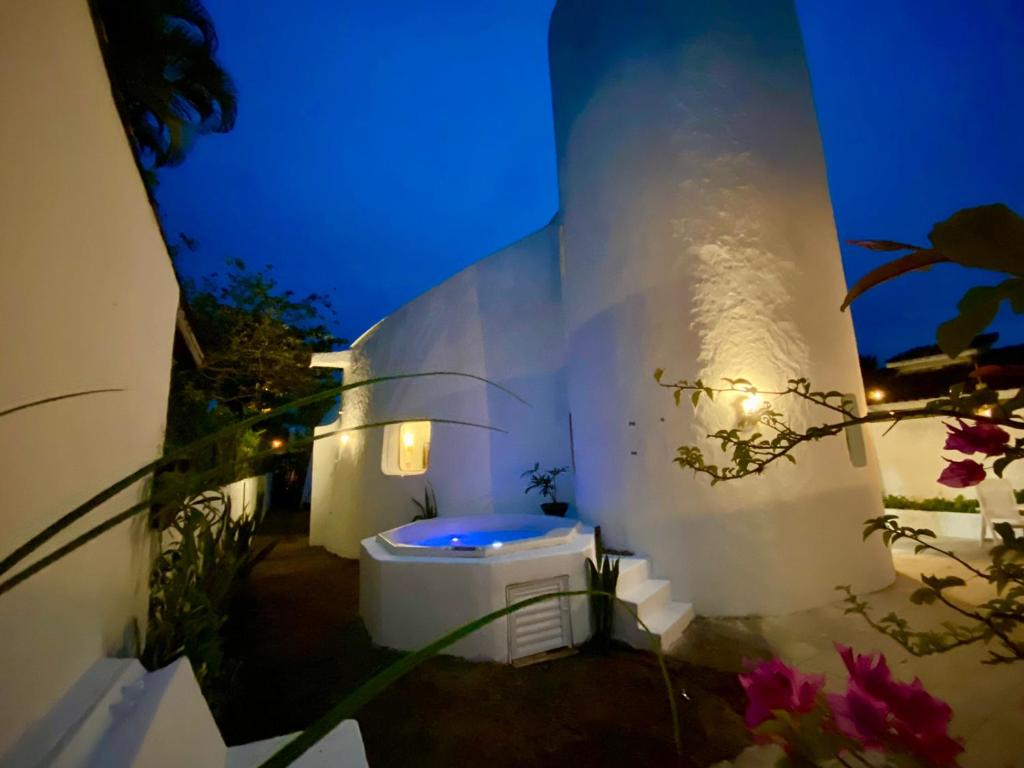 un edificio bianco con vasca da bagno di fronte di Casa estilo Grega com Spa Praia do Pernambuco a Guarujá