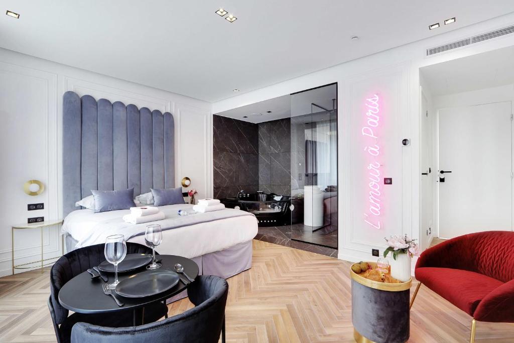 a bedroom with a large white bed and two chairs at Couples Getaway Unit with Jacuzzi - City Center in Paris