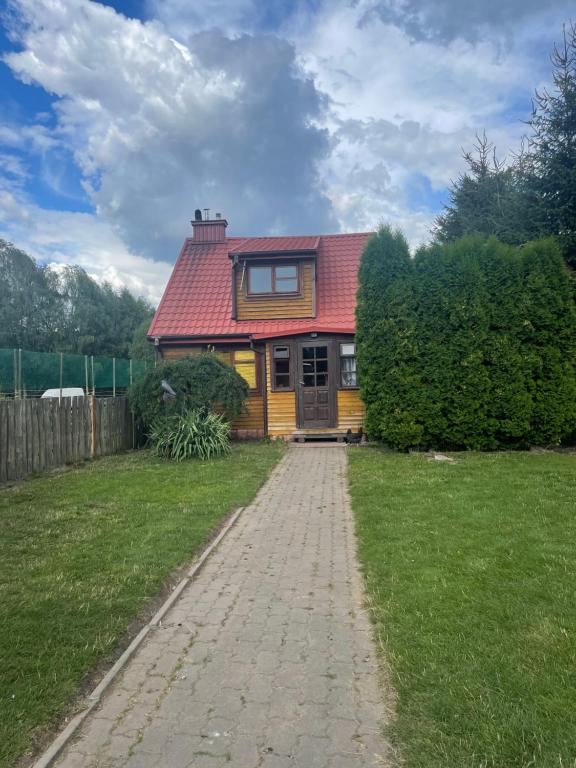 a house with a red roof and a brick driveway at Całoroczny domek rustykalny in Siemiatycze
