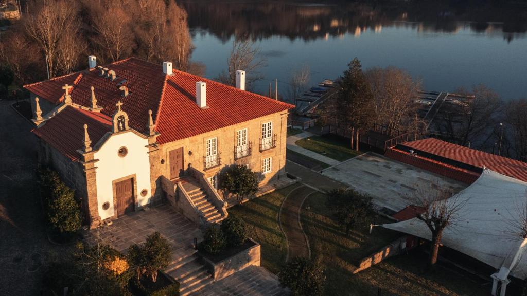 una vista aérea de una gran casa en un lago en Casa da Ribeira, en Marco de Canaveses