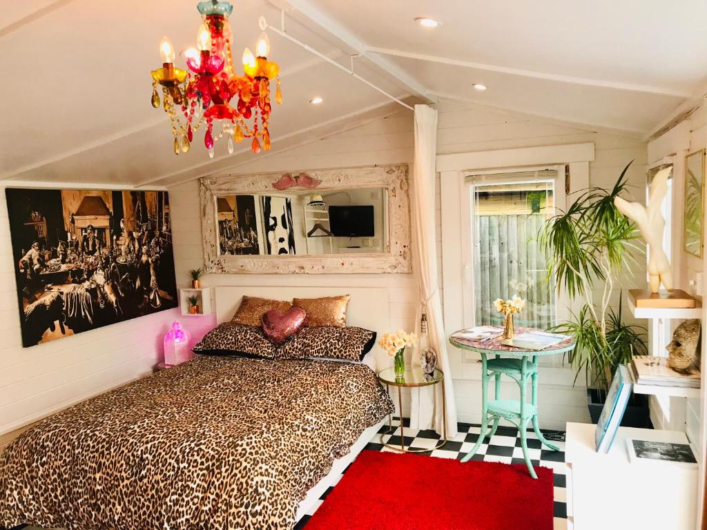 a bedroom with a bed and a chandelier at Ibiza Casa in Kent