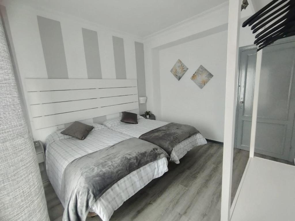 a white bedroom with a large bed in it at Apartamento Ana Maria in San Juan del Puerto