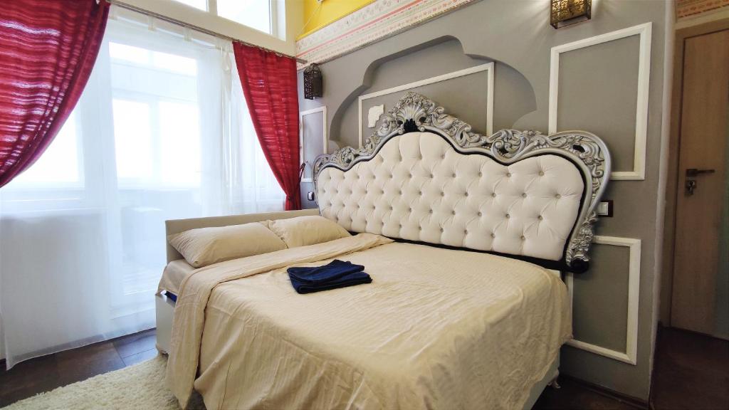 Inessa Center Guest PenthHouse في كيشيناو: غرفة نوم بسرير ابيض عليها قميص ازرق