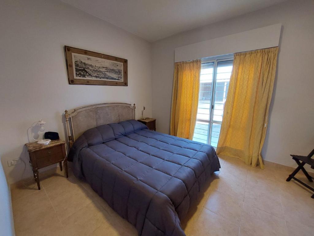 um quarto com uma grande cama azul e uma janela em Departamentos Equipados Realico em Realicó
