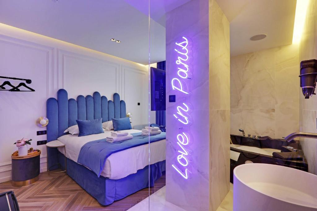 a bedroom with a bed with a neon sign on it at Couples Getaway Unit with Jacuzzi - City Center in Paris