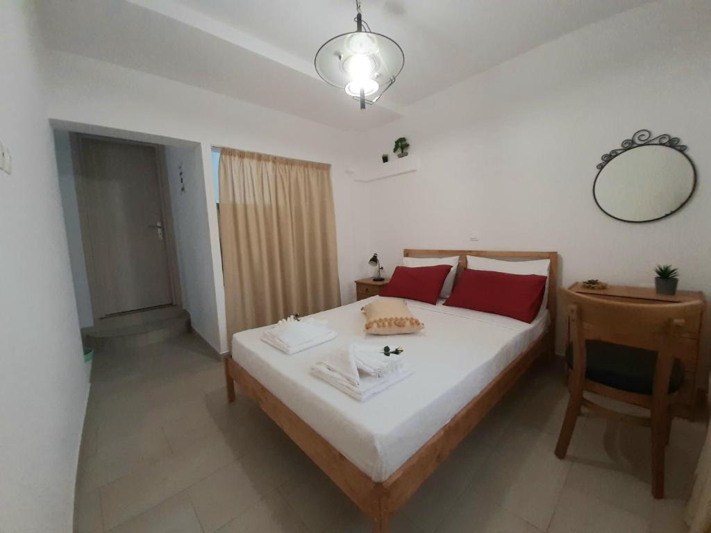um quarto com uma cama, uma mesa e um espelho em Quiet, colourful home in Cyclades em Konizopí