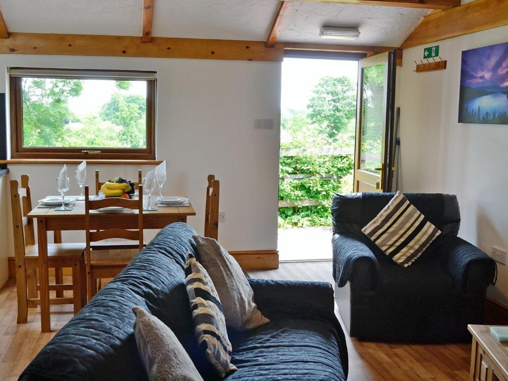 uma sala de estar com um sofá azul e uma mesa em Pheasant Cottage - Ukc3428 em Dalston
