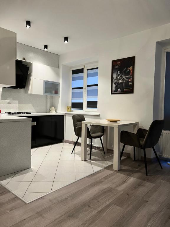 a kitchen and dining room with a table and chairs at Topoliai Apartament Self check -in in Panevėžys