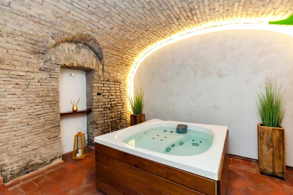 een badkamer met een bad in een bakstenen muur bij Rifugio degli Artisti B&B in Rome