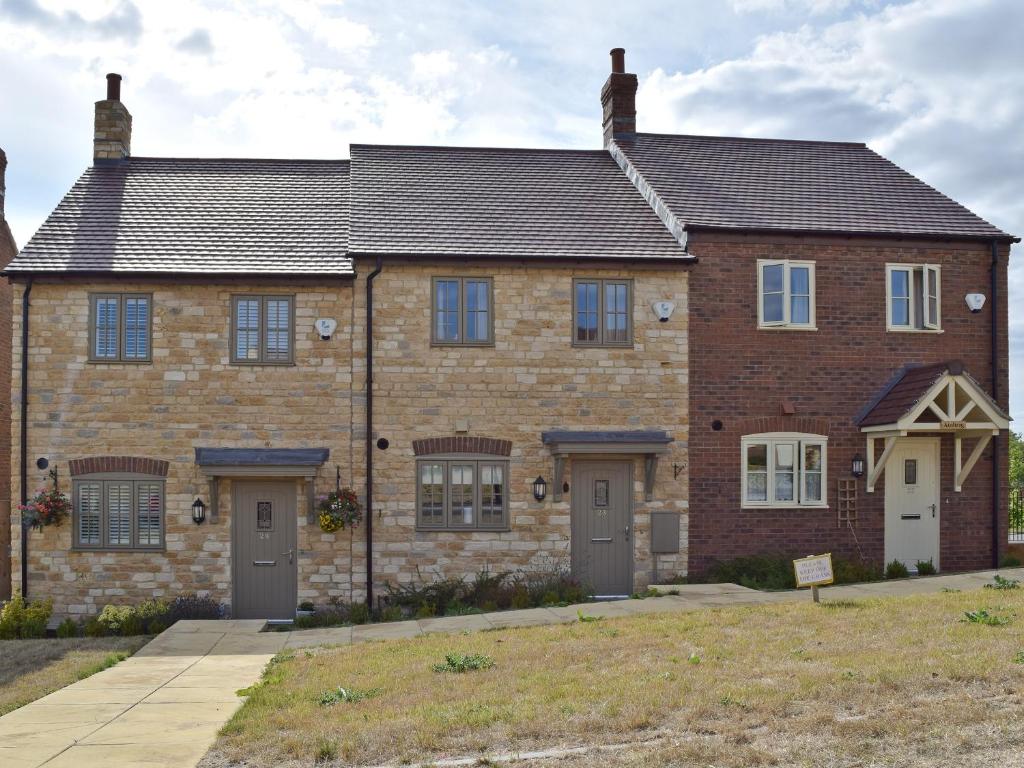 a large brick house with a driveway at Cosy Cotswolds Townhouse in Honington