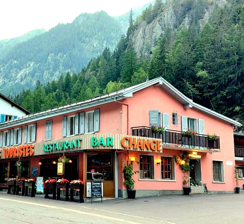 un gran edificio rosa en el lateral de una calle en LES TOURISTES, en Le Chatelard