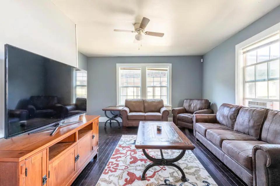 a living room with a large flat screen tv at Cozy Yellow Home near LSU and Downtown in Baton Rouge