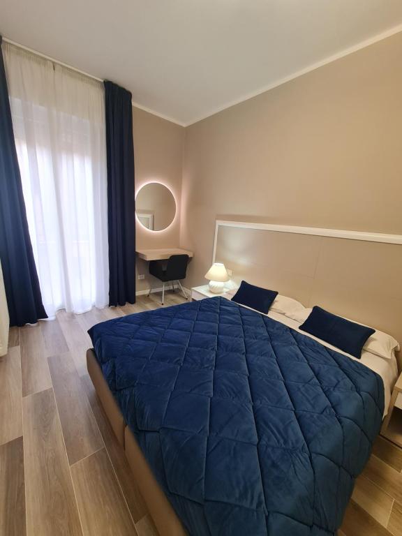 een slaapkamer met een blauw bed en een bureau bij Nel Sole Superior in Bologna