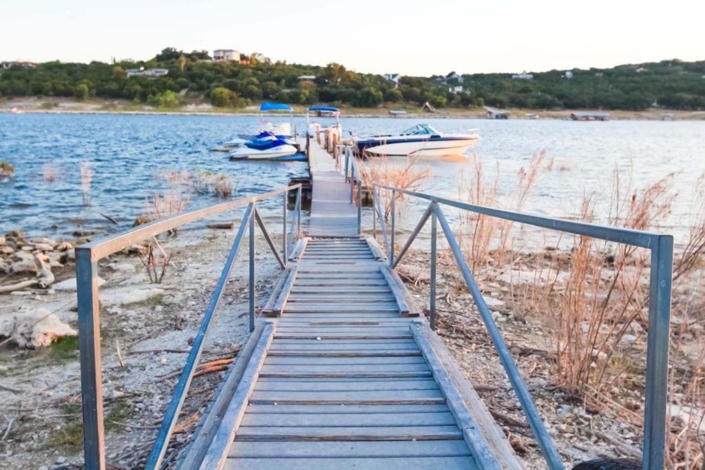 a wooden dock with two boats on the water at The Shores at Lake Travis, a VRI resort in Lago Vista