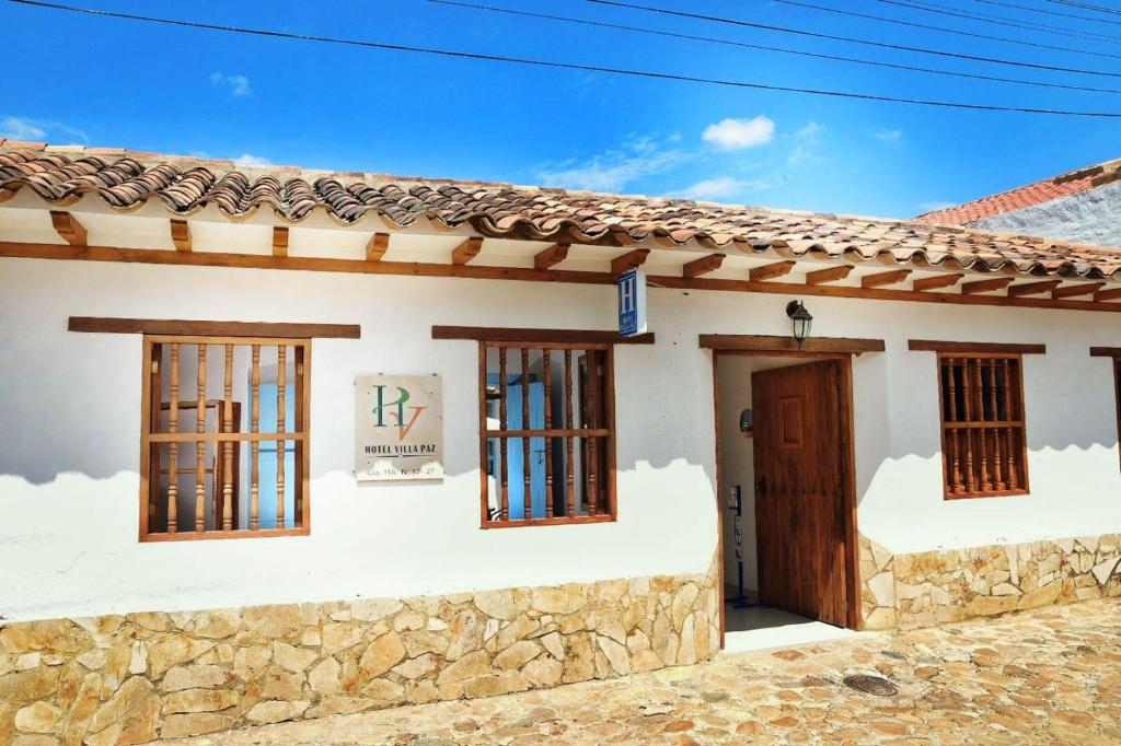 Cette maison blanche dispose de fenêtres et d'une porte. dans l'établissement Hotel Villa Paz, à Villa de Leyva