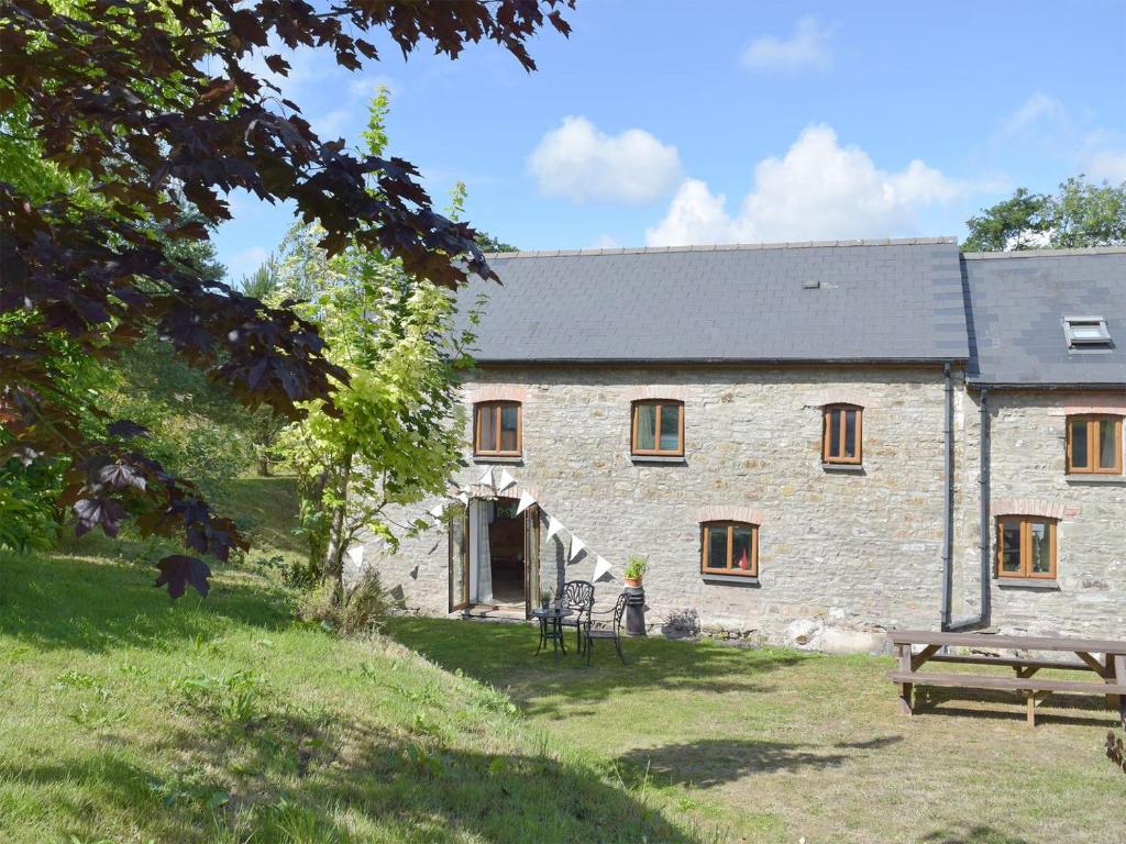 a stone house with a picnic table in front of it at Mill Cottage in Llanybri