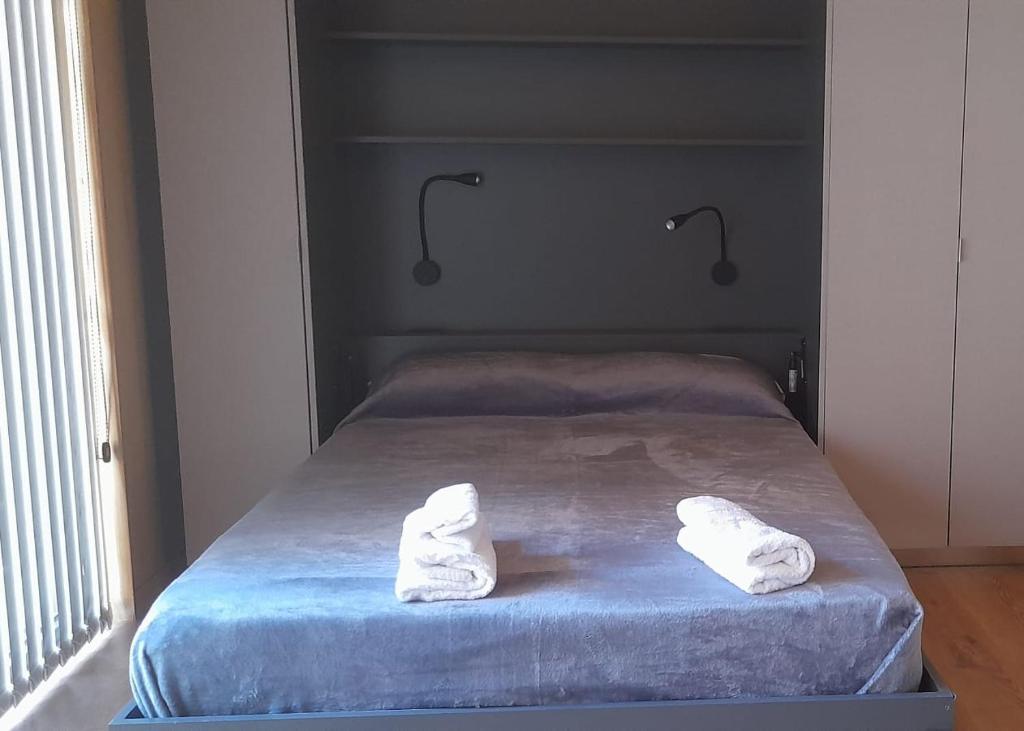 Una cama con dos toallas blancas encima. en Vivero 5 UF 12 en San Martín de los Andes