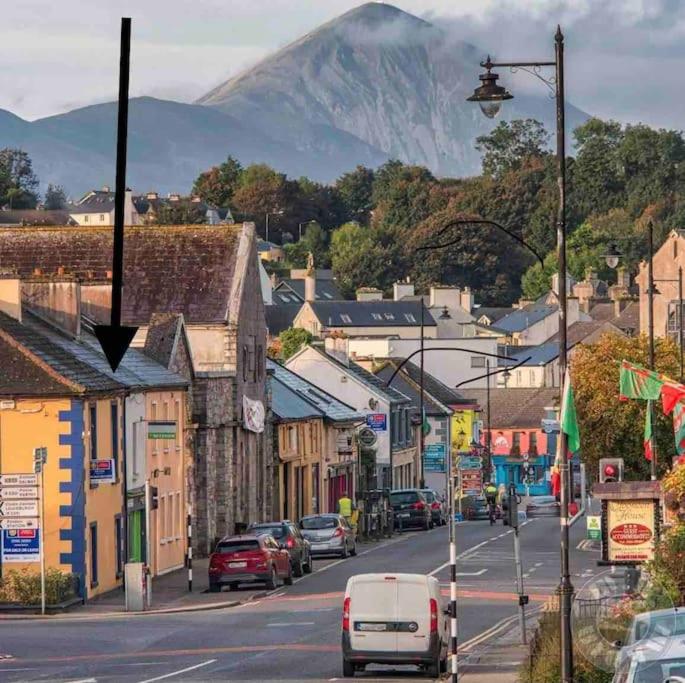 a town with cars parked on a street with a mountain at Westport town centre three bedroom in Mayo