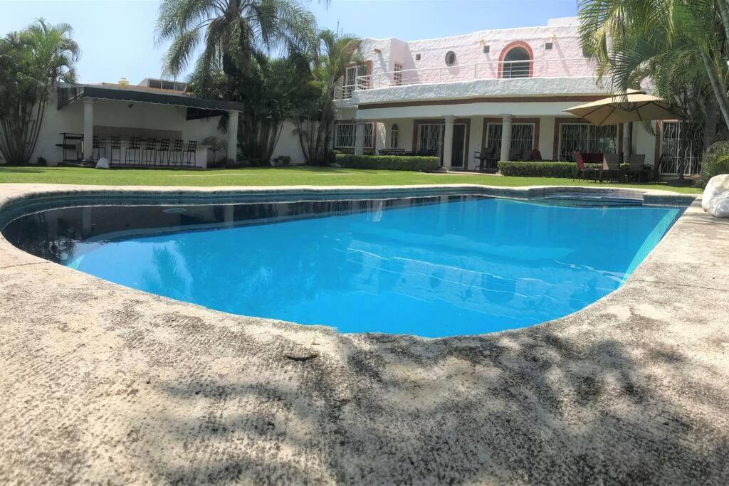 a swimming pool in front of a house at Hermosa Casa llena de vida, jardín y alberca! in Jiutepec