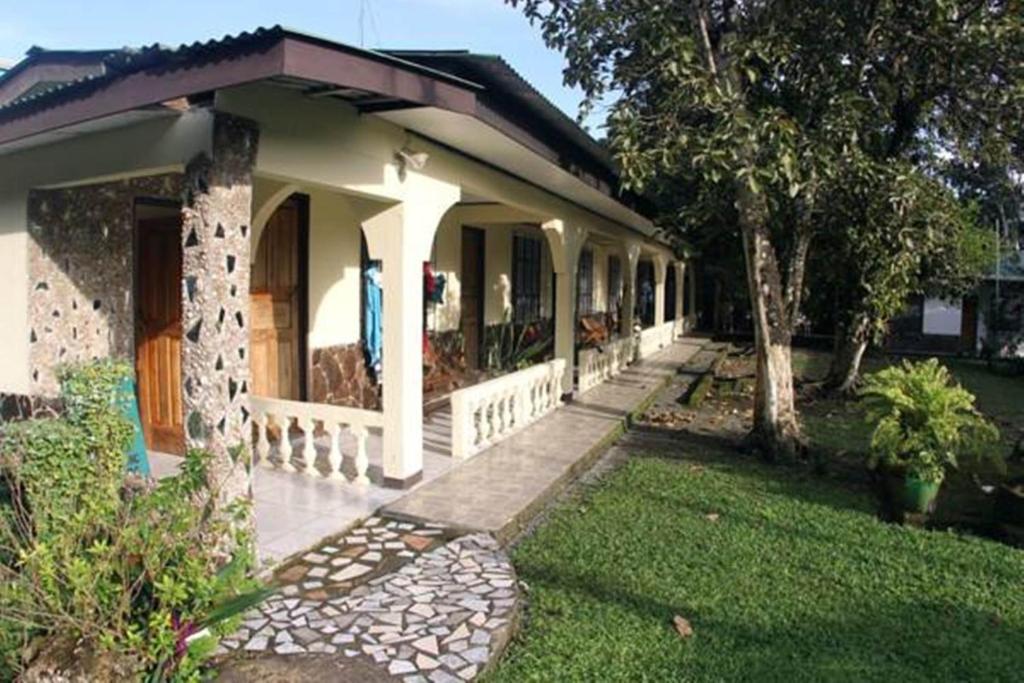 ein kleines Haus mit einer Veranda und einem Hof in der Unterkunft Cabinas Smith in Cahuita