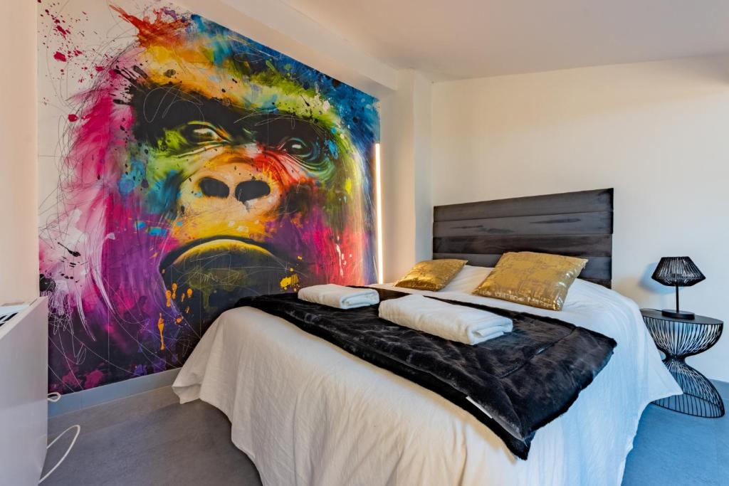 1 dormitorio con una gran pintura en la pared en Solstice T2 Hypercentre SmartTV Wifi, en Pamiers