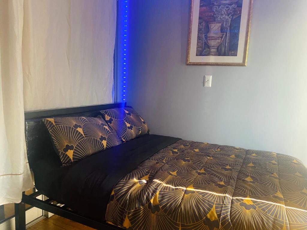een slaapkamer met een bed met een zwart dekbed bij Double-Mirrored Glass Room in Queens in Corona