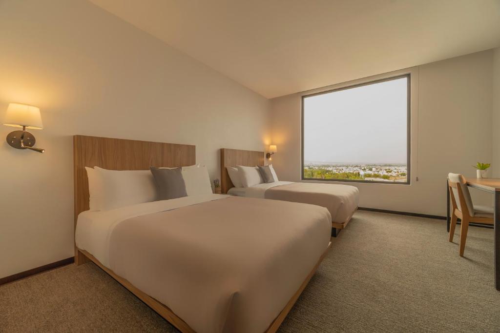 Postel nebo postele na pokoji v ubytování Stadía Suites Querétaro Centro Histórico