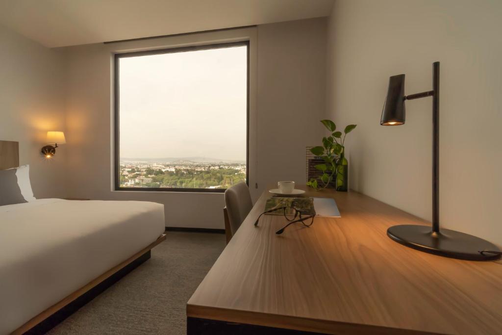Postel nebo postele na pokoji v ubytování Stadía Suites Querétaro Centro Histórico