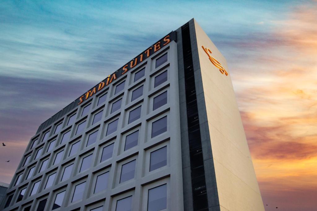 a building with a sign on the top of it at Stadía Suites Querétaro Centro Histórico in Querétaro