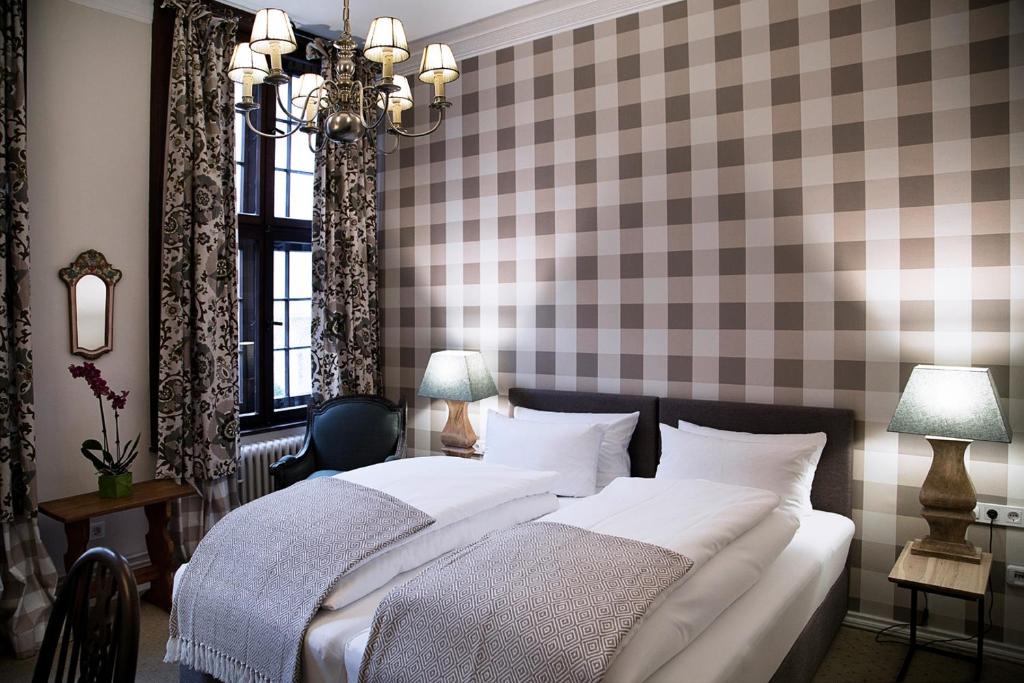 a bedroom with a bed and a checkerboard wall at Hotel Alt Nürnberg in Hamburg