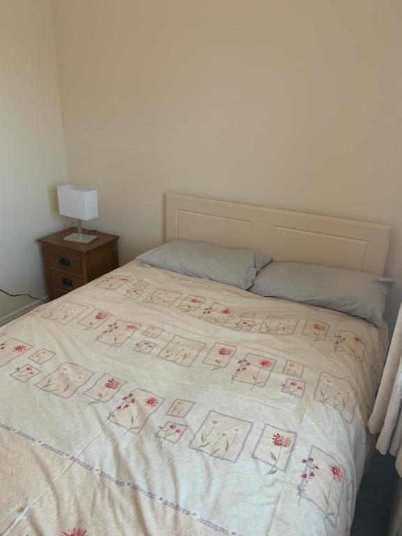 um quarto com uma cama com uma colcha branca em One Bedroom Apartment Dublin em Dublin