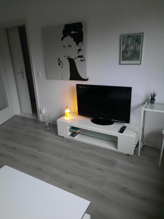 een woonkamer met een flatscreen-tv op een wit entertainmentcentrum bij Happy Living in Mülheim an der Ruhr