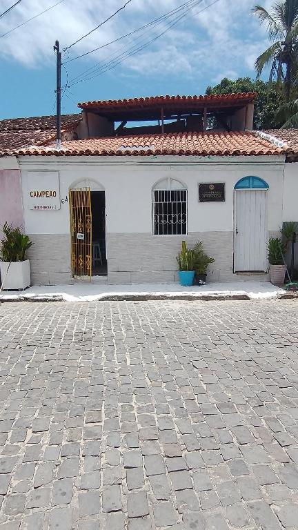 un edificio blanco con una puerta a un lado en Pousada e Residencial Recanto do Campeão, en Porto Seguro