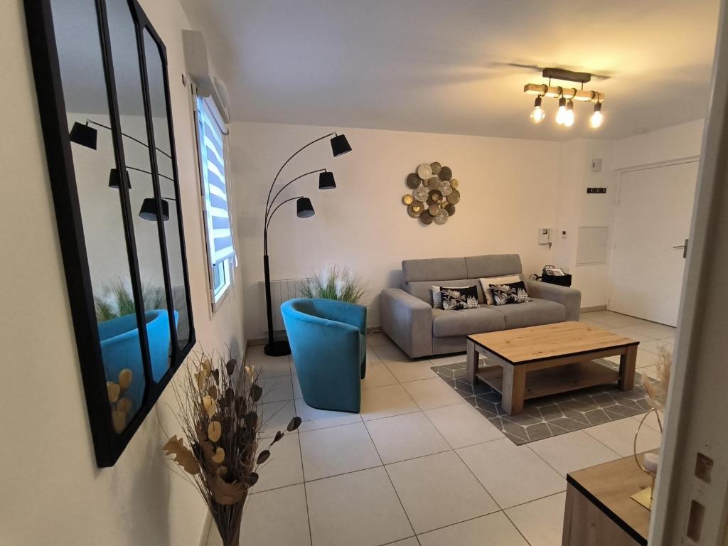 ein Wohnzimmer mit einem Sofa und einem Tisch in der Unterkunft Le colibri in Dinard