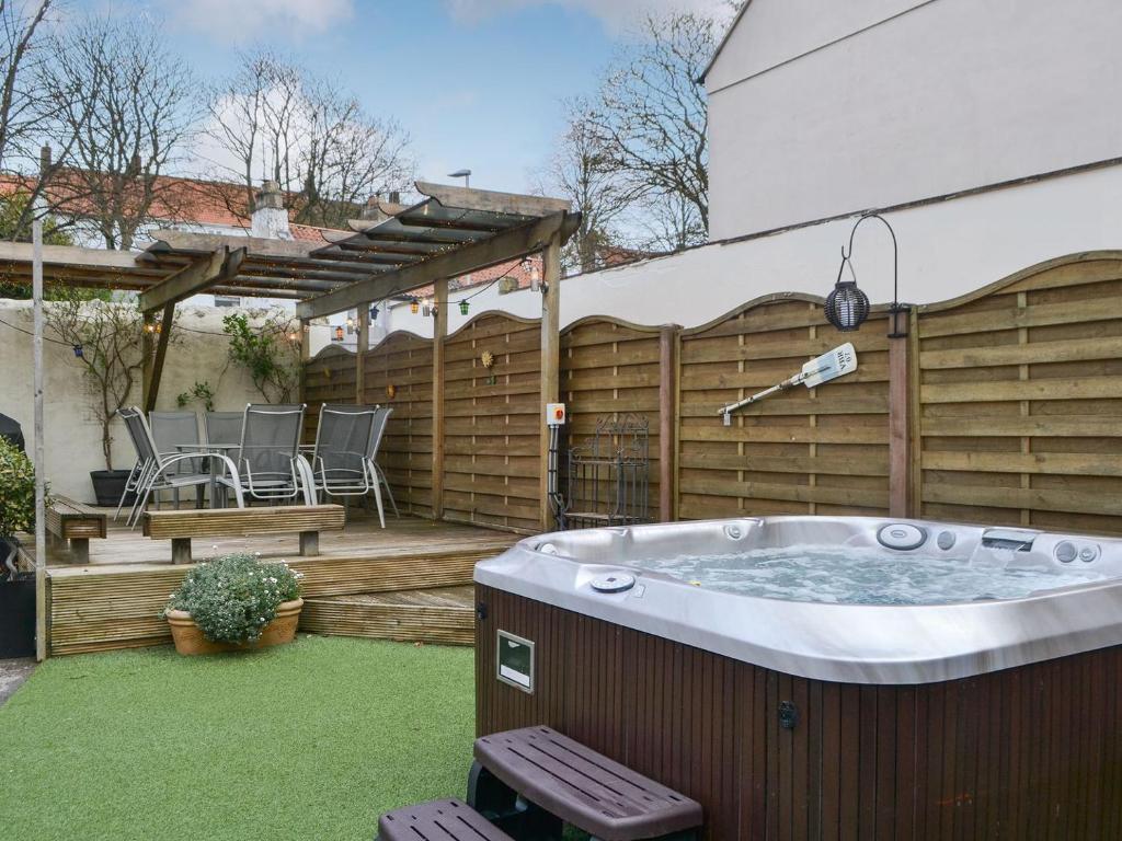 a backyard with a hot tub and a wooden fence at The Dun Cow in Bishop Middleham
