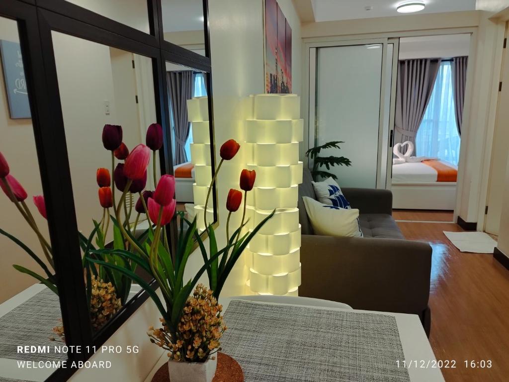 ein Wohnzimmer mit roten Tulpen in einer Vase auf einem Tisch in der Unterkunft Celandine Residence by DMCI in Manila