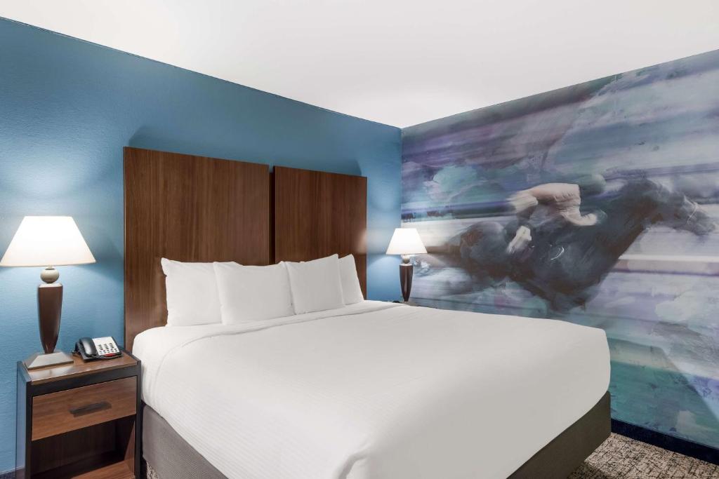 a hotel room with a bed and a painting on the wall at Best Western Winners Circle in Hot Springs