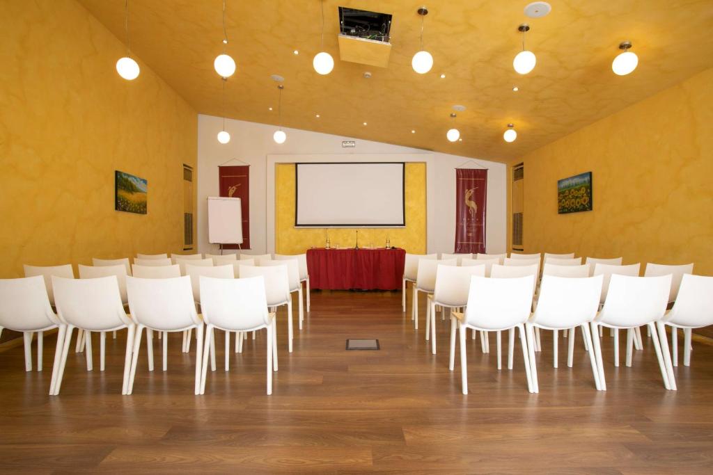 uma sala de conferências com cadeiras brancas e um ecrã de projecção em Best Western Ai Cavalieri Hotel em Palermo