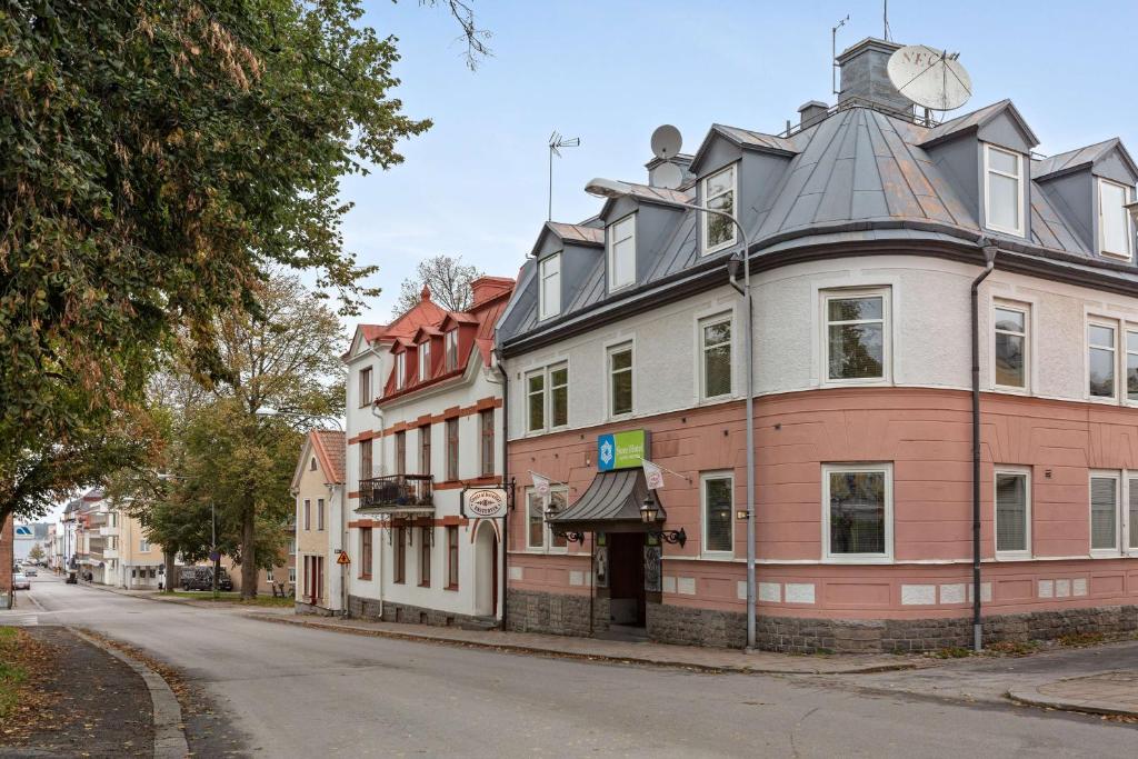 ein großes Gebäude mit einem Dach auf einer Straße in der Unterkunft Sure Hotel by Best Western Centralhotellet in Västervik