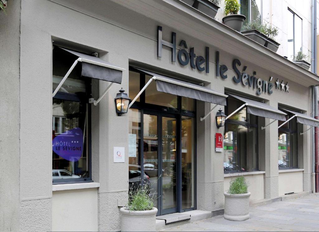 een winkel voor een winkel met een bord erop bij Hotel Le Sevigne - Sure Hotel Collection by Best Western in Rennes