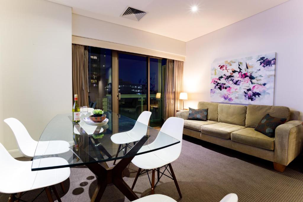 a living room with a glass table and white chairs at Melbourne Royal Botanical Gardens 2BR in Melbourne