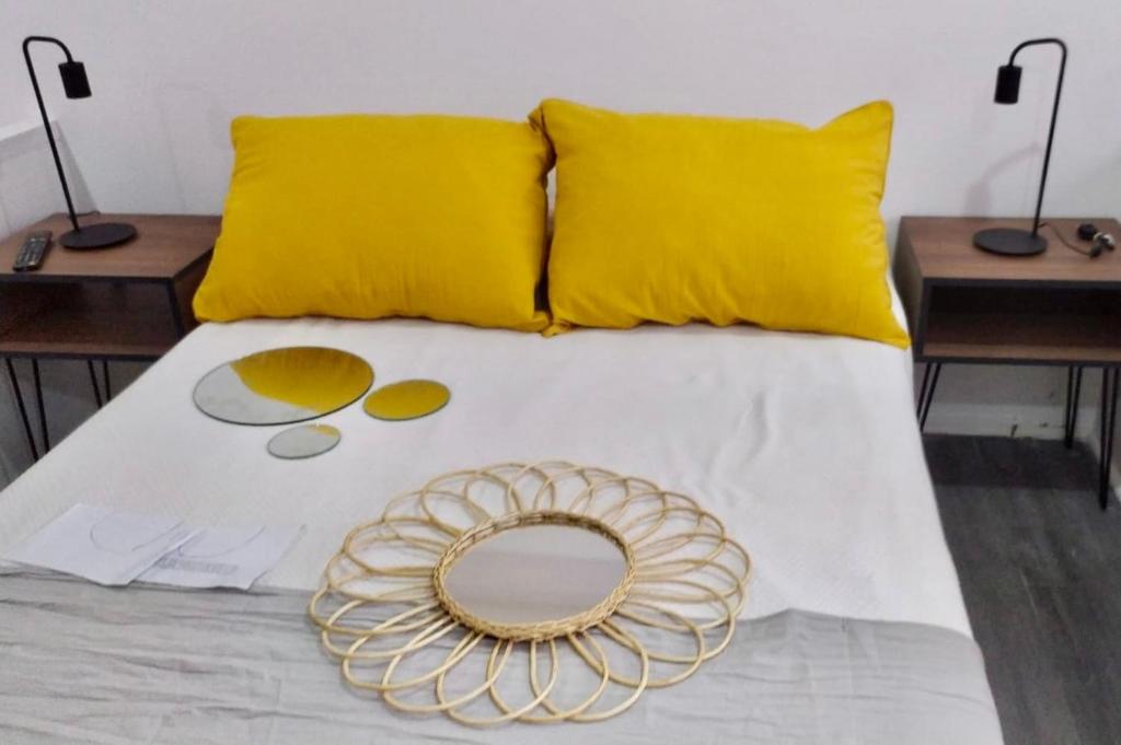Una cama con almohadas amarillas y una placa de oro. en Montañeses 2830 Duplex Flat en Buenos Aires