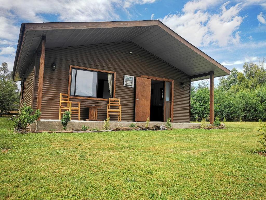 Casa pequeña con porche y césped en Cabaña Canto del Zorzal, en Villarrica