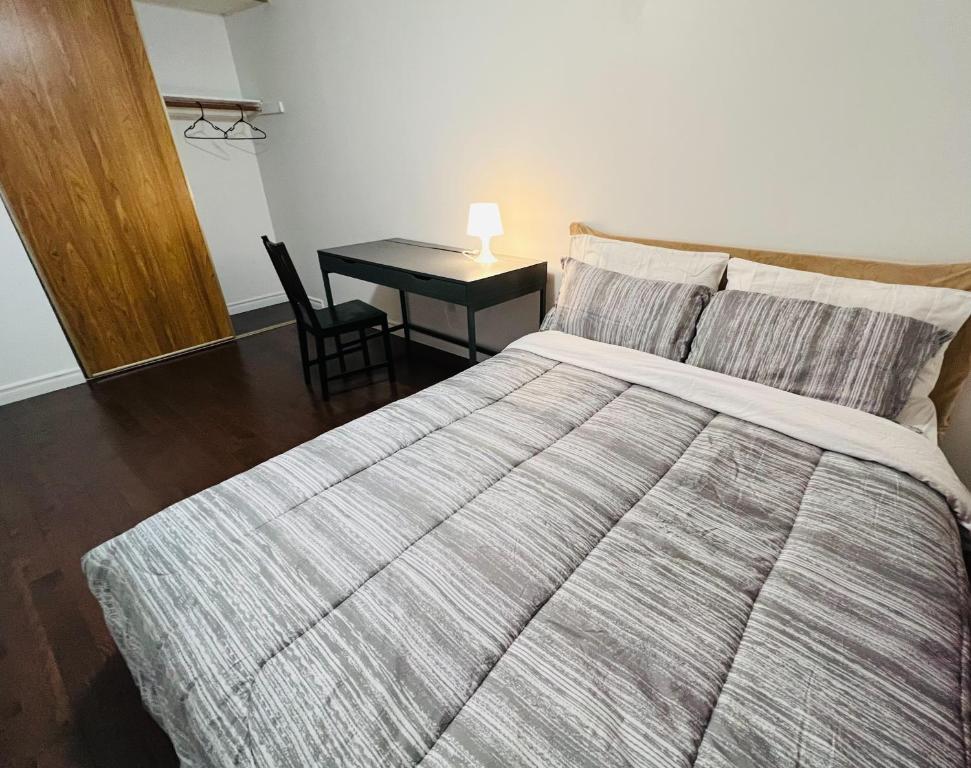 多倫多的住宿－ComfyRoom，一间卧室配有一张床和一张带台灯的桌子