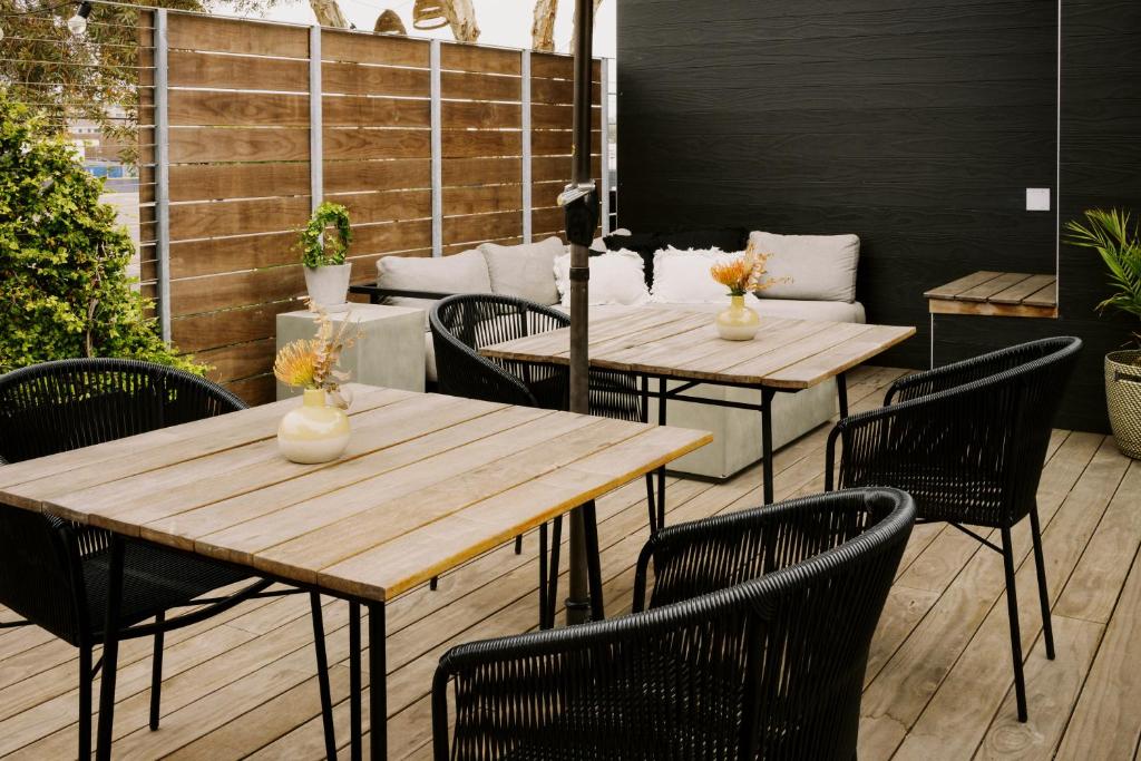 two wooden tables and chairs on a patio at Twelve Senses Retreat, a Member of Design Hotels in Encinitas