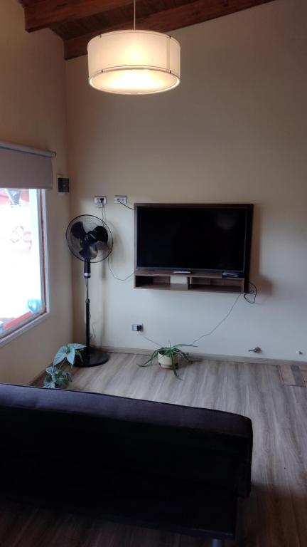 sala de estar con TV de pantalla plana en la pared en Laguna de los Cisnes en Perito Moreno