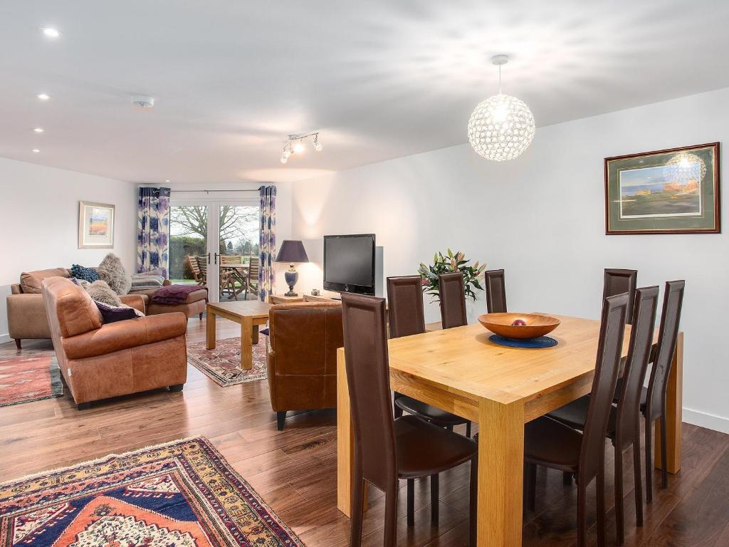a dining room and living room with a table and chairs at Fieldview - Uk40947 in Auchtermuchty