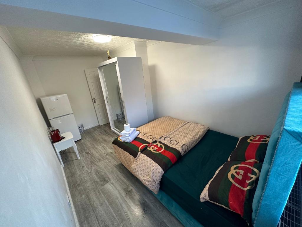 a small bedroom with a bed and a mirror at Double Room with Private Shower room Close to City center and UOB Free Onsite Parking Private Fridge with Shared Kitchen and Lounge access in Northfield