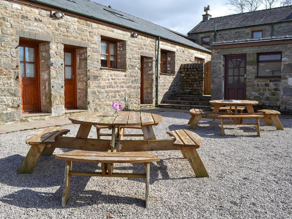 un grupo de mesas de picnic frente a un edificio en Lakeland View en Scotforth